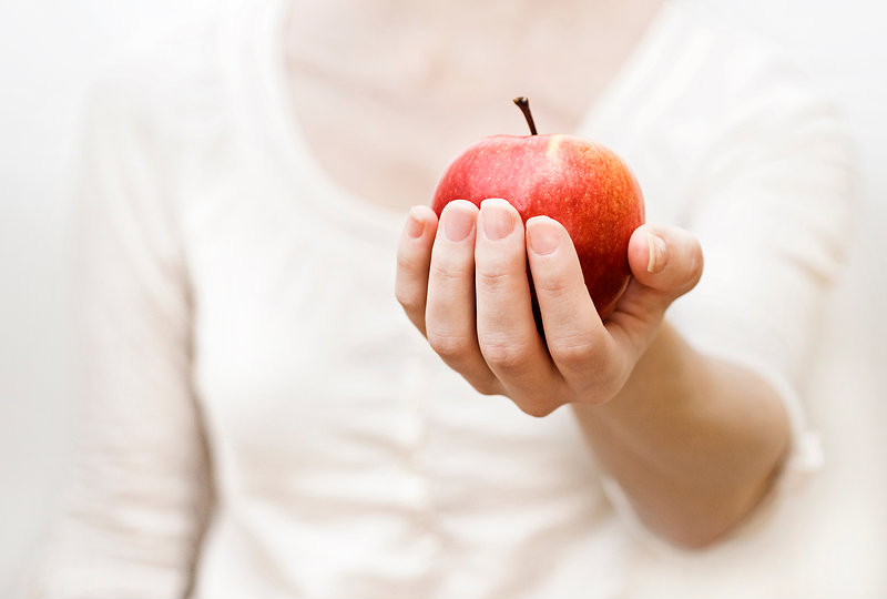 Frau mit Apfel in Hand